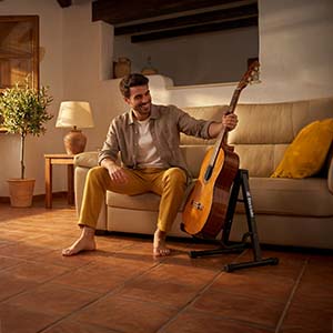 Guitarrista en el salón de casa con el soporte Bixtride
