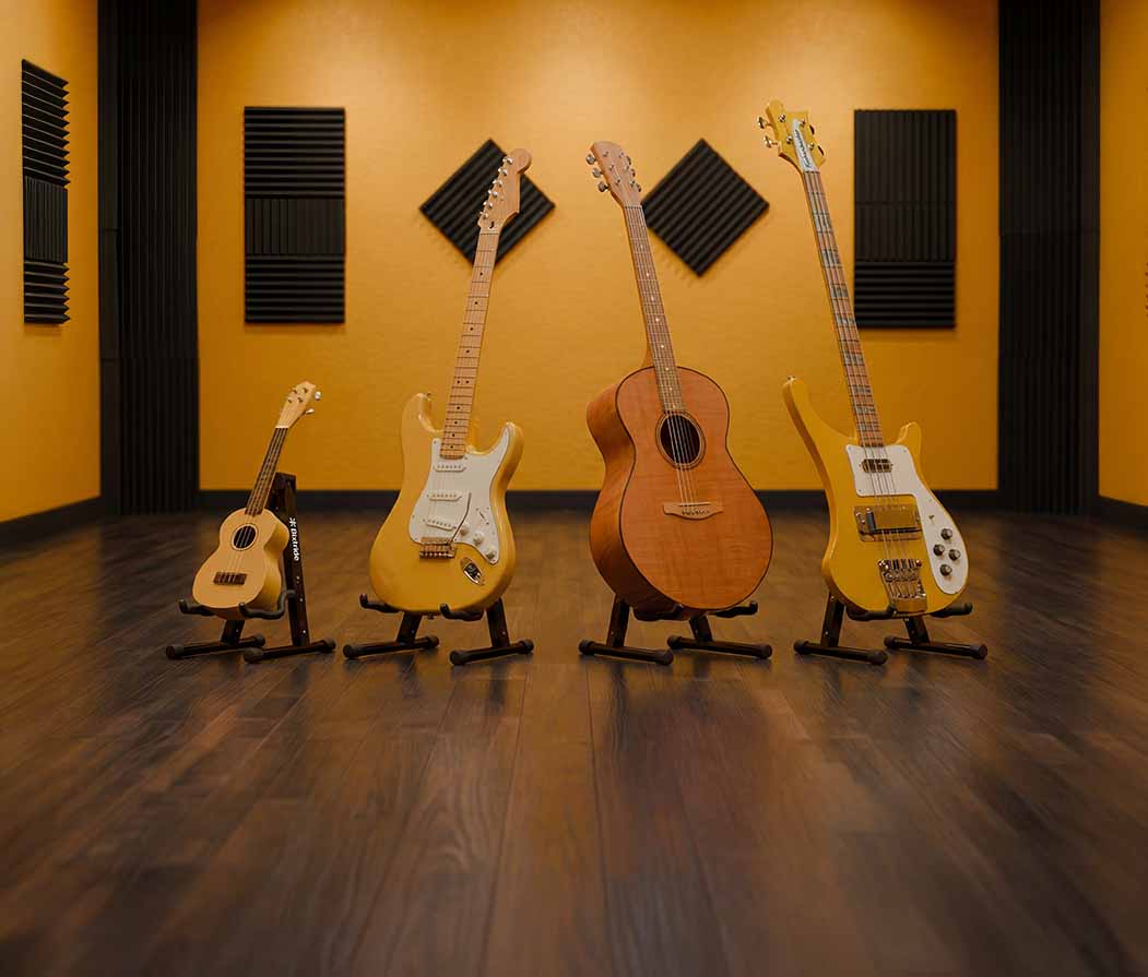 Ukelele, guitarra eléctrica, acústica y bajo sobre soportes Bixtride